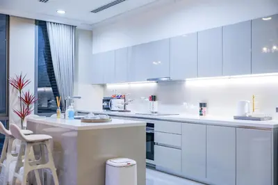 a kitchen with white cabinets and a bar stool at Sukhumvit-Thonglor Luxury Pool Club Villa 5 Mins to BTS \u7d20\u5764\u9038-\u901a\u7f85 \u8c6a\u83ef\u6703\u6240\u6cf3\u6c60\u5225\u5885 5\u5206\u9418\u5230\u9054\u5730\u9435 in Bangkok