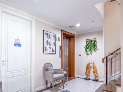a living room with a chair and a door at Sukhumvit-Thonglor Luxury Pool Club Villa 5 Mins to BTS \u7d20\u5764\u9038-\u901a\u7f85 \u8c6a\u83ef\u6703\u6240\u6cf3\u6c60\u5225\u5885 5\u5206\u9418\u5230\u9054\u5730\u9435 in Bangkok