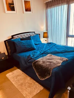 a bedroom with a blue bed with blue pillows at 1BR at Thonglor BTS InfinityPool overlooking city in Bangkok