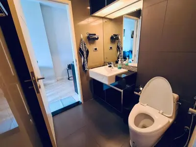 a bathroom with a toilet and a sink and a mirror at 1BR at Thonglor BTS InfinityPool overlooking city in Bangkok