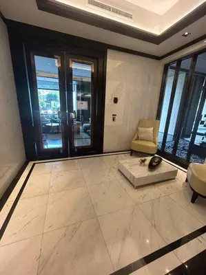 a living room with a couch and a chair in a building at 1BR at Thonglor BTS InfinityPool overlooking city in Bangkok