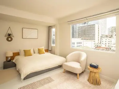 a bedroom with a bed and a chair and a window at Cozy studio room - 2 guests in the heart of Silom - 6B in Bang Rak