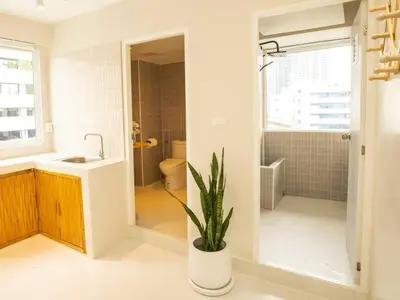 a bathroom with a sink and a toilet and a plant at Cozy studio room - 2 guests in the heart of Silom - 6B in Bang Rak