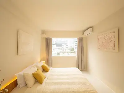 a bedroom with a bed with yellow pillows and a window at Cozy 2-bedroom apartment in Silom city center - 6A in Bang Rak