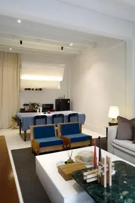 a living room with a table and blue chairs at Nap by Snooze in Bangkok