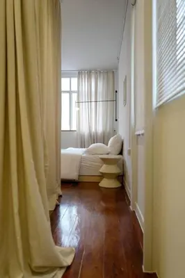 a hallway with white curtains and a living room at Nap by Snooze in Bangkok