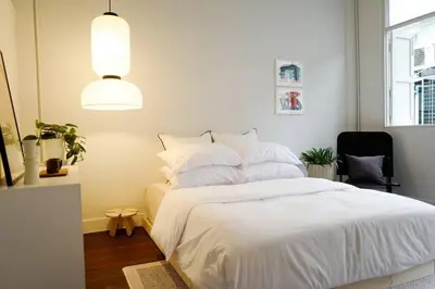 a bedroom with a white bed and a black chair at Nap by Snooze in Bangkok