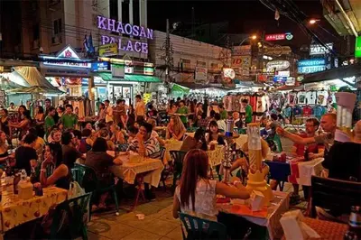 a crowd of people sitting at tables in a market at night at XX GO INN Khaosan road The Grand Palace โกอินน์ ถนนข้าวสาร กรุงเทพมหานคร in Bangkok