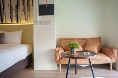 a living room with a couch and a table at ZAYN Phrom Phong Hotel in Bangkok
