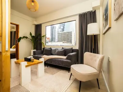 a living room with a couch and a chair at 2 Bedroom apartment at Silom with city center view - 5A in Bangkok