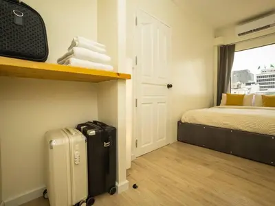 a small room with a bed and a suitcase at 2 Bedroom apartment at Silom with city center view - 5A in Bangkok