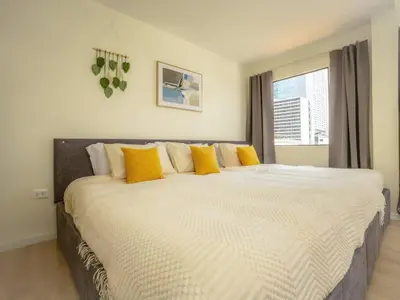 a bedroom with a large bed with yellow pillows at Cozy studio room for 3 guests at Center-Silom - 5B in Bang Rak