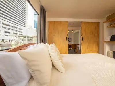 a bedroom with a white bed with white pillows at 2-Bedroom Penthouse in the heart of Silom - 4A in Bang Rak