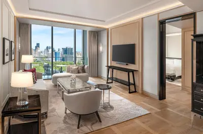 a living room with a couch and a television at The Ritz-Carlton, Bangkok in Bangkok