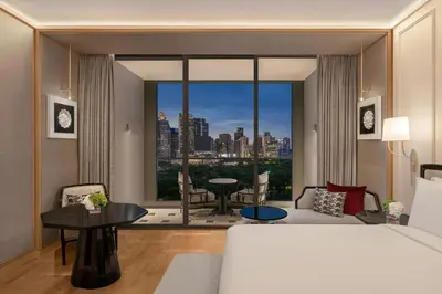 a bedroom with a bed and a large window at The Ritz-Carlton, Bangkok in Bangkok