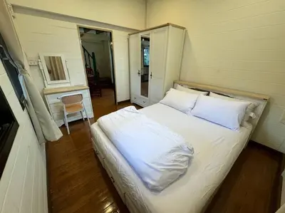 a bedroom with a bed with white sheets and pillows at Thairin House Old town BKK in Dusit
