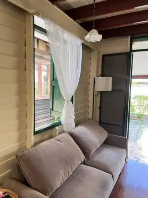 a couch in the corner of a room with a window at Thairin House Old town BKK in Dusit