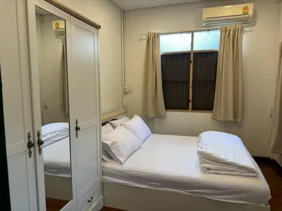 a small room with a bed and a window at Thairin House Old town BKK in Dusit