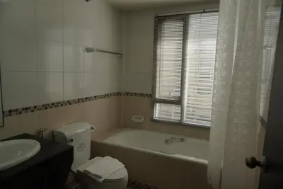 a bathroom with a tub and a toilet and a sink at Phatana Court in Bangkok
