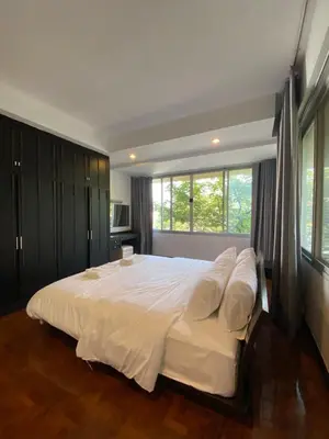 a large white bed in a bedroom with a window at Phatana Court in Bangkok