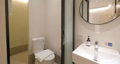 a bathroom with a toilet and a sink and a mirror at SimpleStay Chatuchak, SureStay Collection by Best Western in Bangkok