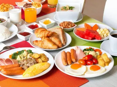 a table with plates of breakfast food on it at Boutique hotel Axis Bangkok in Bangkok