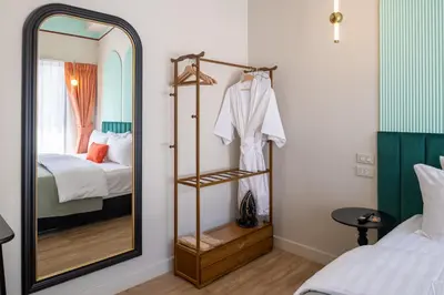 a mirror in a room with a bed and a bedroom at Boutique hotel Axis Bangkok in Bangkok