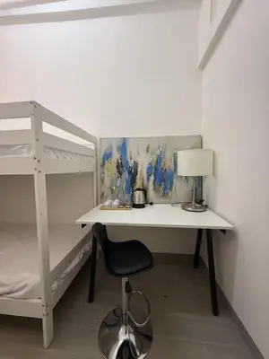a bedroom with a desk and a bunk bed at Twenty Two Place Hostel - Sukhumvit 22 in Bangkok