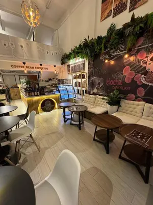 a restaurant with tables and couches in a room at Twenty Two Place Hostel - Sukhumvit 22 in Bangkok