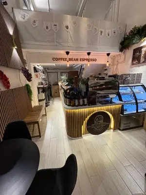 a coffee shop with a counter in a room at Twenty Two Place Hostel - Sukhumvit 22 in Bangkok