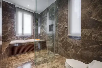 a bathroom with a toilet and a glass shower at Ekkamai Villa Sleeps 12 with Cinema in Bangkok