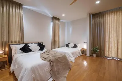 a bedroom with two beds with white sheets at Ekkamai Villa Sleeps 12 with Cinema in Bangkok