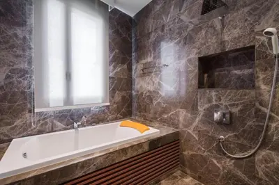 a bathroom with a tub and a window at Ekkamai Villa Sleeps 12 with Cinema in Bangkok