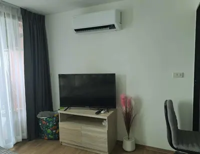 a living room with a flat screen tv on a stand at Cybiq Ratchada 32 by Pikul in Bangkok