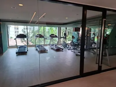 a gym with several treadmills and elliptical machines at Cybiq Ratchada 32 by Pikul in Bangkok