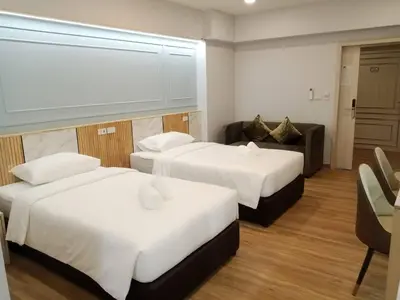a hotel room with two beds and a couch at Wellness World Chiva 89 in Ban Zong Katiam