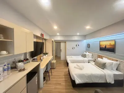 a hotel room with two beds and a desk at Wellness World Chiva 89 in Ban Zong Katiam