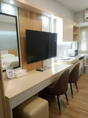 a desk with a television and chairs in a room at Wellness World Chiva 89 in Ban Zong Katiam