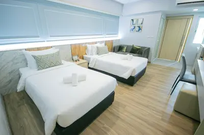 a hotel room with two beds and a couch at Wellness World Chiva 89 in Ban Zong Katiam