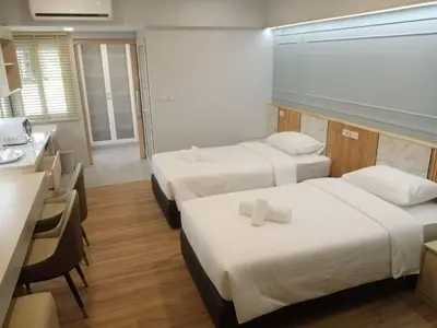 a hotel room with two beds and a kitchen at Wellness World Chiva 89 in Ban Zong Katiam