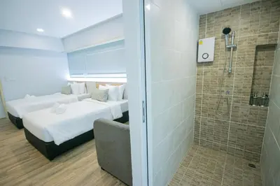 two beds in a room with a shower and a bathroom at Wellness World Chiva 89 in Ban Zong Katiam