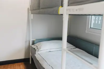 a bunk bed in a room next to a window at My Sukhumvit Villa in Bangkok