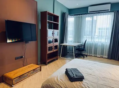 a bedroom with a bed and a desk and a television at Ekkamai\u4e09\u5367\u4e09\u536b\u5c0f\u522b\u5885\u72ec\u680b\u5e26\u505c\u8f66\u4f4d in Bangkok