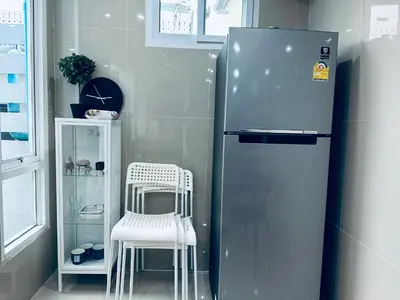 a refrigerator and a white chair in a kitchen at hana villa in Bangkok