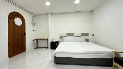 a bedroom with a large bed and a wooden door at Megun 10 L in Bangkok