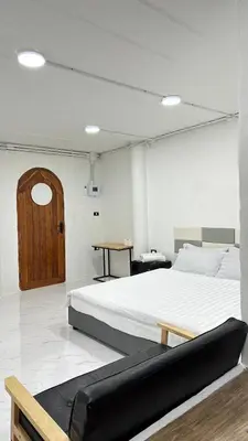 a bedroom with a large bed and a wooden door at Megun 10 L in Bangkok