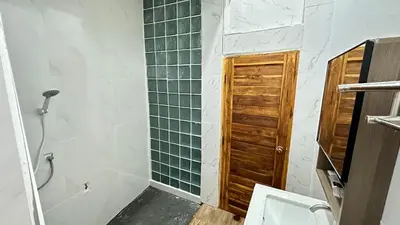 a bathroom with a toilet and a shower with green tiles at Megun 10 L in Bangkok