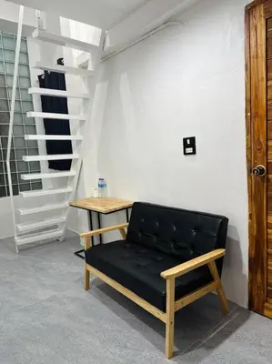 a black bench sitting in a room with a staircase at Megun 10 Duplex in Bangkok