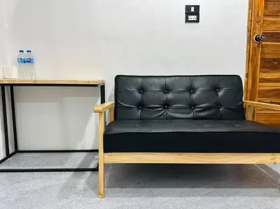 a black leather couch sitting next to a table at Megun 10 Duplex in Bangkok