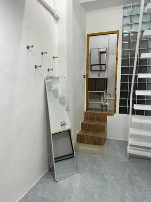 a mirror in a bathroom with a staircase and a mirror at Megun 10 Duplex in Bangkok